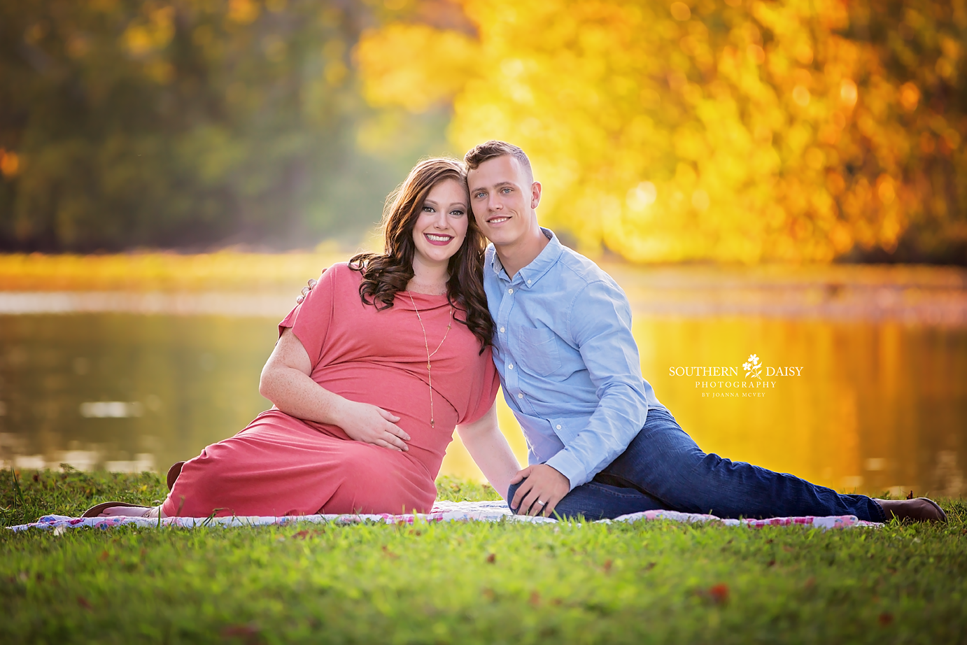 pregnant mother sitting on blanket with husband with creek and trees in background - hendersonville tn maternity photographer