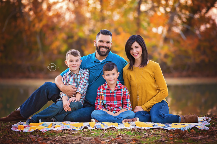 Family of 4 sitting on quilt near creek - Nashville Family Photographer | Jo McVey Photography